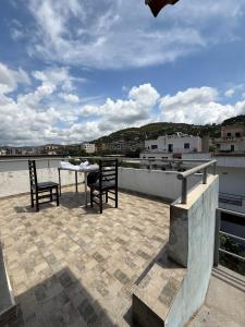 a patio with two chairs and a table on a roof at Luna Apartment in Berat