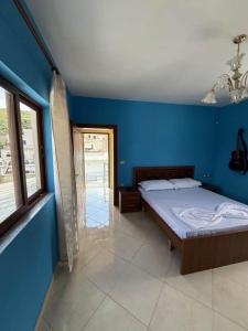 a bedroom with a bed in a blue wall at Luna Apartment in Berat