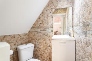 een badkamer met een toilet, een wastafel en een spiegel bij Casa do Pereira in Lissabon