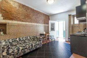 een woonkamer met een bank en een bakstenen muur bij Casa do Pereira in Lissabon