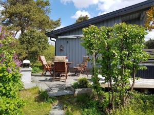 eine Terrasse mit Stühlen und einem Tisch im Garten in der Unterkunft Sjarmerende liten gjestehytte in Fredrikstad