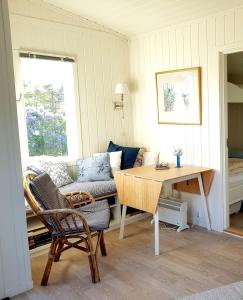 ein Wohnzimmer mit Tisch und Couch in der Unterkunft Sjarmerende liten gjestehytte in Fredrikstad