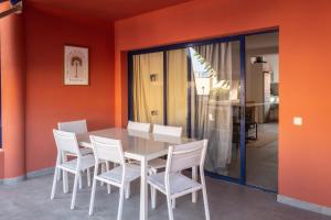 a dining room with orange walls and a table and chairs at Bungalow - Playa Meloneras in San Bartolomé
