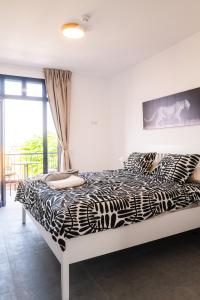 a black and white bed in a room with a window at Bungalow - Playa Meloneras in San Bartolomé +34 photos