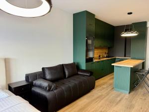 a living room with a couch and a kitchen at Drahan Apartment 28 in Radom