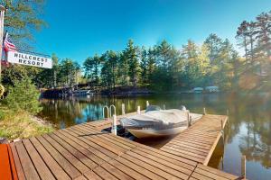 een boot ligt aangemeerd aan een steiger op een meer bij Fishermans Cottage in Manitowish Waters