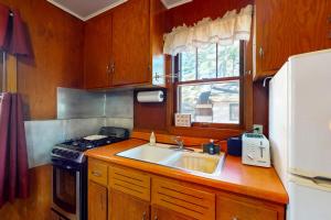 een kleine keuken met een spoelbak en een koelkast bij Fishermans Cottage in Manitowish Waters +16 foto's