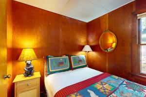 een slaapkamer met een bed, een lamp en een spiegel bij Fishermans Cottage in Manitowish Waters