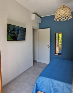 a blue bedroom with a bed and a picture on the wall at Alis home 100 mt dal mare in Loano +26 photos