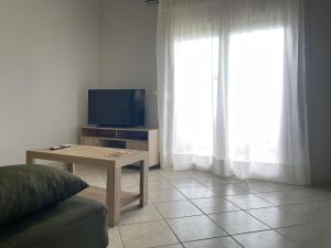 a living room with a table and a tv and a couch at Maria's Beach House in Karfas
