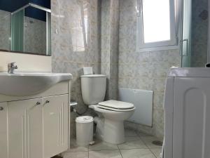 a bathroom with a toilet and a sink and a mirror at Maria's Beach House in Karfas +25 photos