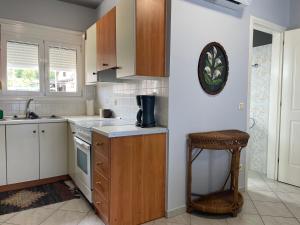 a kitchen with a counter and a sink and a stool at Maria's Beach House in Karfas