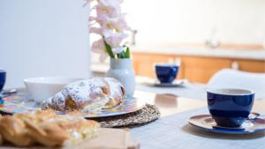 a table with two plates of food and cups of coffee at 006B - Casa Mare Blu, CENTRO di Riva Trigoso e 300m dalla SPIAGGIA in Riva Trigoso +6 photos