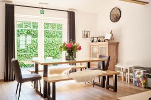 a dining room with a table and chairs and a window at Vakantiewoning De Gulden Sleutels in Kruibeke