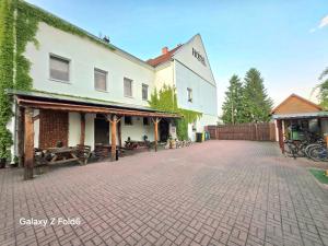 a building on a brick road next to a fence at Bike Hostel&Camp in Przewóz