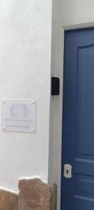 une porte bleue avec un panneau sur le côté d'une maison dans l'établissement La casa de los Abuelos, à Alcalá de los Gazules