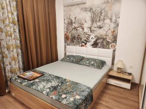 a bedroom with a bed and a painting on the wall at Lili's Azur beach Apartment in Varna City