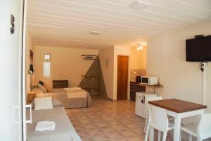 a hotel room with a bed and a table and a television at Alameda Reserve Apart in El Calafate