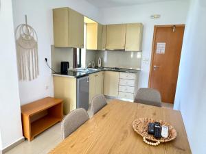 a kitchen with a wooden table with chairs and a dining room at Pachia Ammos Falasarna in Falasarna