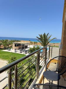 a balcony with a chair and a view of the ocean at Pachia Ammos Falasarna in Falasarna
