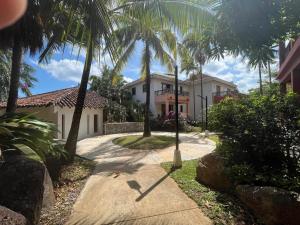 una casa con palme di fronte a un vialetto di Ocean Loft - Surf & Serenity Retreat a Los Destiladeros