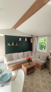 a living room with a couch and a table at MOBILHEIM HERZ LAUWERSOOG - Chalet Schildhoek in Lauwersoog +10 photos