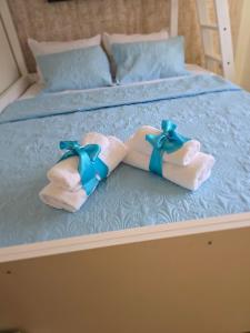 a bed with two towels and blue bows on it at Golden Sea View -Thasos House in Skala Potamias