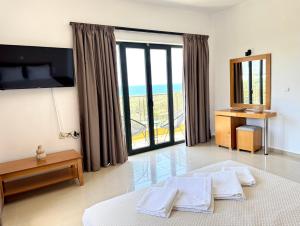 a bedroom with a bed and a view of the ocean at Pachia Ammos Falasarna in Falasarna