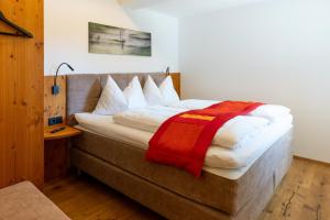 a bedroom with a bed with a red blanket on it at Haus Alpenblick in St. Wolfgang