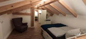 a bedroom with a bed and a chair in a attic at Lord Michael Chalet in Bodenmais