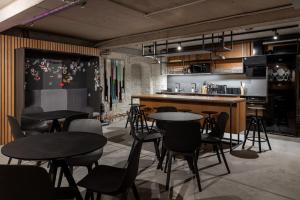 a restaurant with tables and chairs and a kitchen at Gertrude Hotel self check-in in Riga