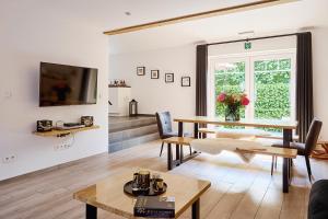 a living room with a table and a window at Vakantiewoning De Gulden Sleutels in Kruibeke