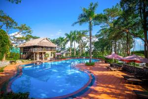 a swimming pool at a resort with palm trees at Sai Gon Ha Long Hotel in Ha Long