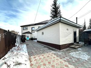 a small white building in front of a house at Дом в Бурабай in Borovoye