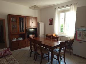 a kitchen with a dining room table and a refrigerator at Appartamento Rosa in Savio di Ravenna
