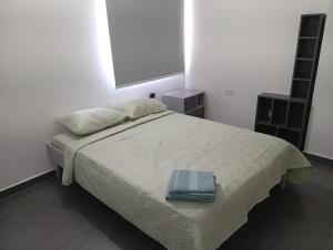a bedroom with a bed with a blue towel on it at Apartamento Yaque in El Yaque