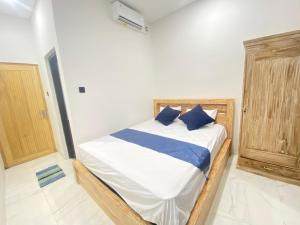 a bedroom with a bed with blue pillows on it at SH Hotel Kuta- 20 Second to the Beach by Micky Studio in Legian