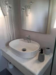 a bathroom with a white sink and a mirror at Pyrgi house, Ipsos Corfu in Ýpsos