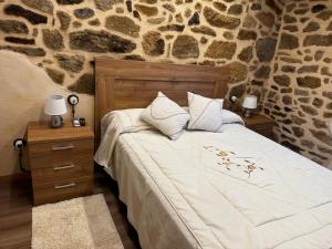 a bedroom with a bed and two night stands with lamps at La Casa de los Abuelos in Fermoselle