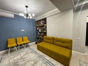 sala de estar con sofá y 2 sillas amarillas en Milana, en Bishkek