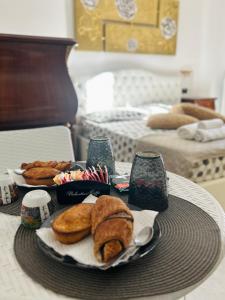 a table with a tray of bread and pastries on it at Blue Marine Affitta Camere in Porto Cesareo