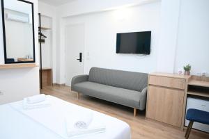 a living room with a couch and a tv at EMAR Beachfront Hotel Ksamil in Ksamil