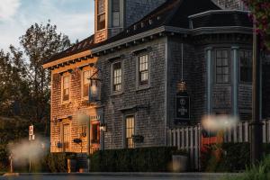a large brick house with a sign on it at The Cooper's Inn in Shelburne