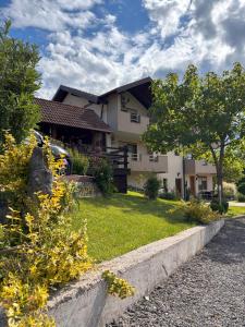 a house with a grassy yard in front of it at Guest House Bunčić Rooms in Slunj +26 photos