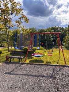 a park with three swings and a picnic table at Guest House Bunčić Rooms in Slunj