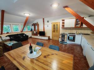 a living room with a wooden table and a kitchen at apartma Pohorc - Kostanj in Hočko Pohorje +15 photos