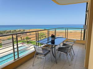 a balcony with a table and chairs and the ocean at Pachia Ammos Falasarna in Falasarna