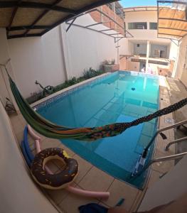 a hammock sitting next to a swimming pool at Spondylus Home in Máncora
