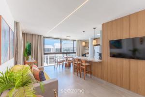 a living room and dining room with a tv and a table at Modern and sophisticated apartments near the beach in Maraú – VLL in Marau