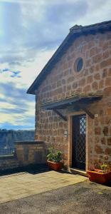 a brick building with a door and two plants at Antica Rupe Casa Vacanze in Castel SantʼElia